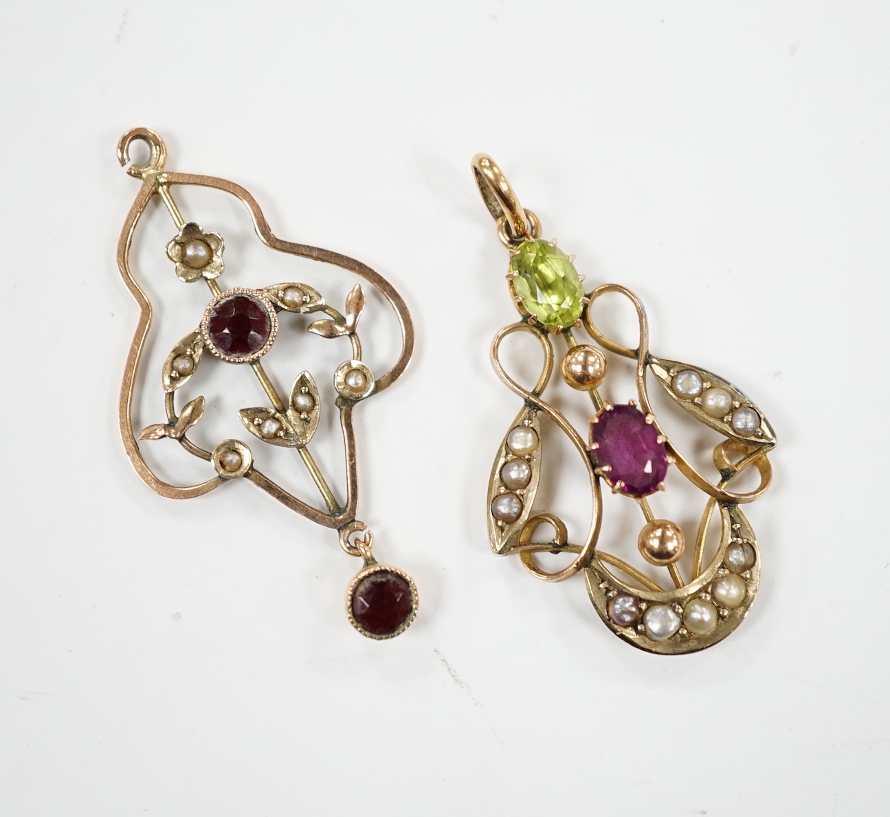 An early 20th century 9ct , peridot, garnet and seed pearl set cluster pendant, in the Suffragette colours, 32mm and one other yellow metal and gem set pendant.